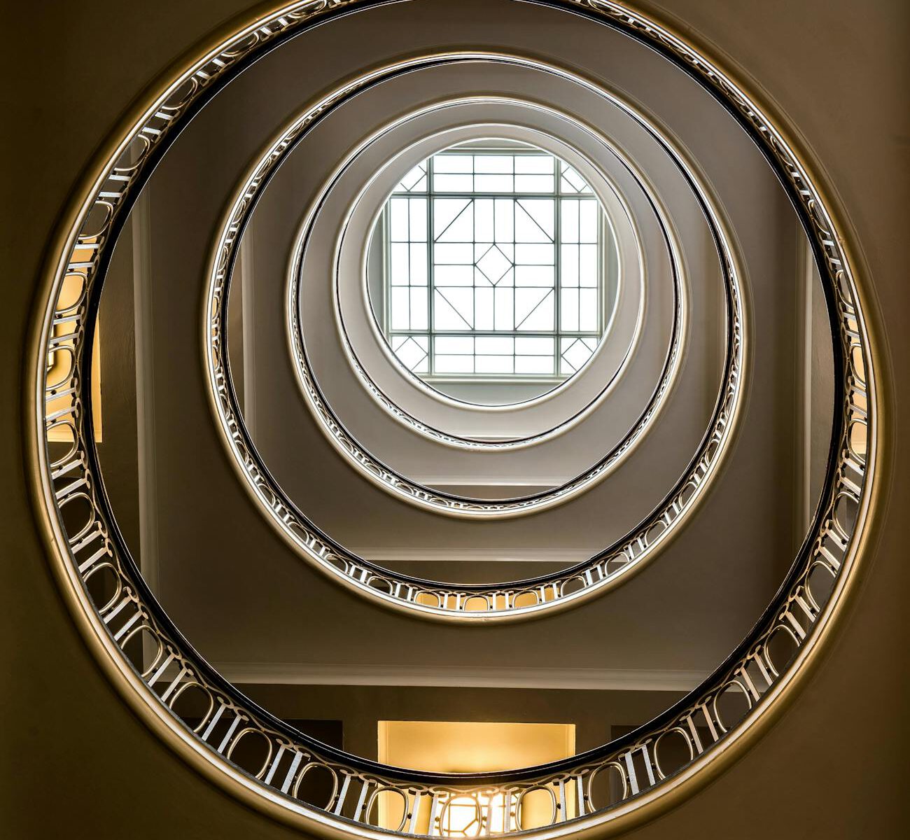 low angle shot of a spiral staircase and window in the ceiling