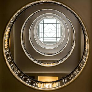 low angle shot of a spiral staircase and window in the ceiling